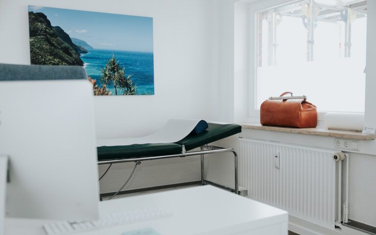 Minimalistisches weißes Schlafzimmer mit Bett, Wandbild mit Meeresmotiven und einer hellbraunen Tasche auf der Fensterbank