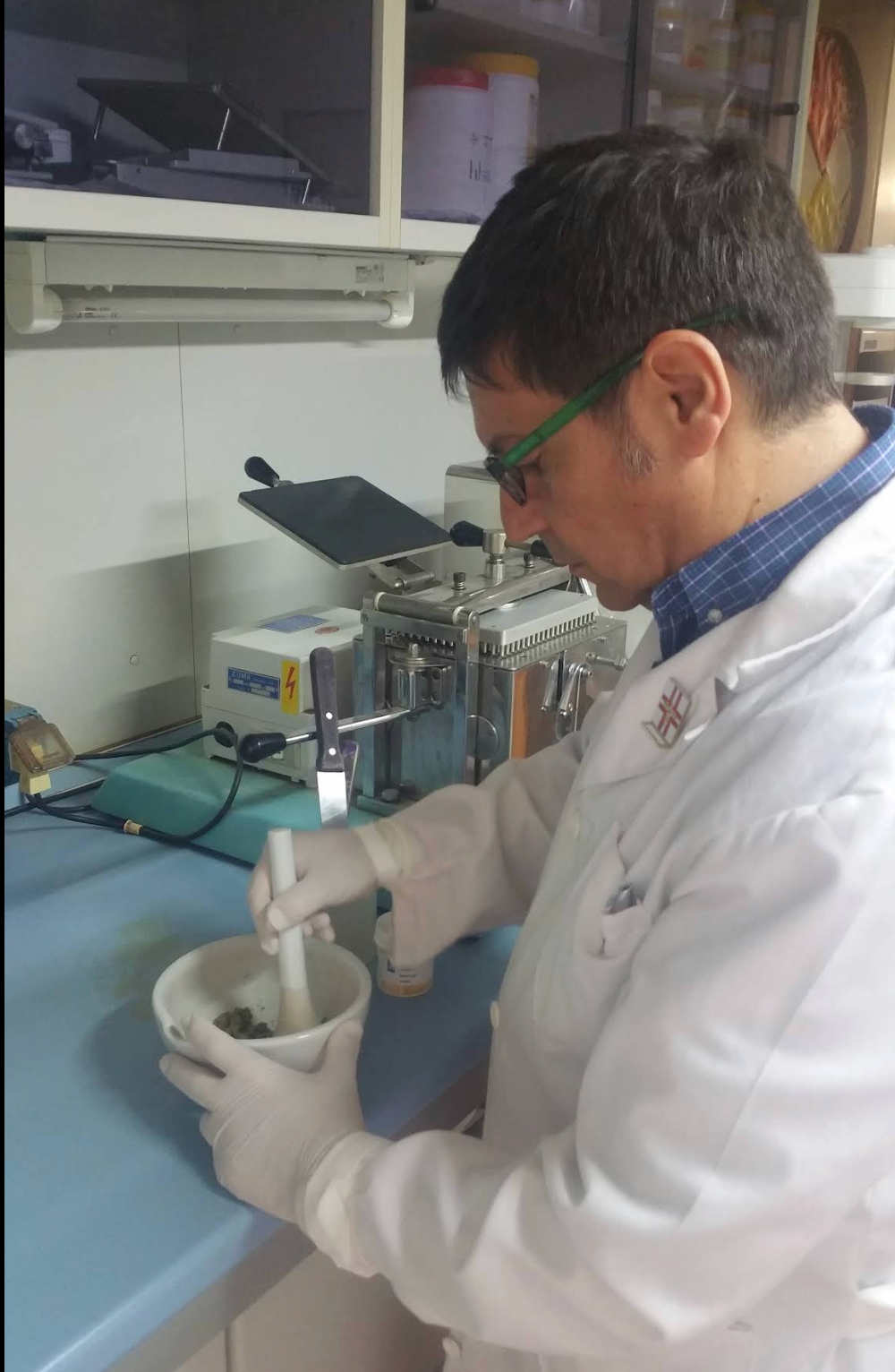 Un farmacista con la barba aiuta una donna in farmacia: entrambi guardano il flacone del medicinale.