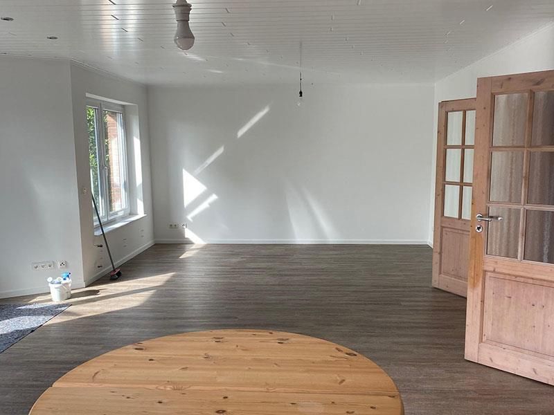 In der Mitte des Raumes steht ein runder Holztisch.