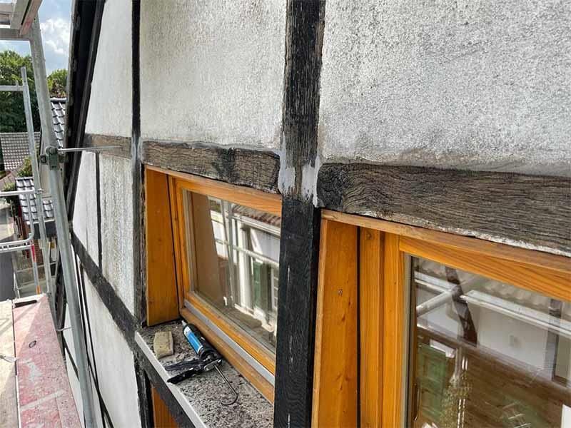 An der Seite eines Gebäudes wird ein Fenster repariert.