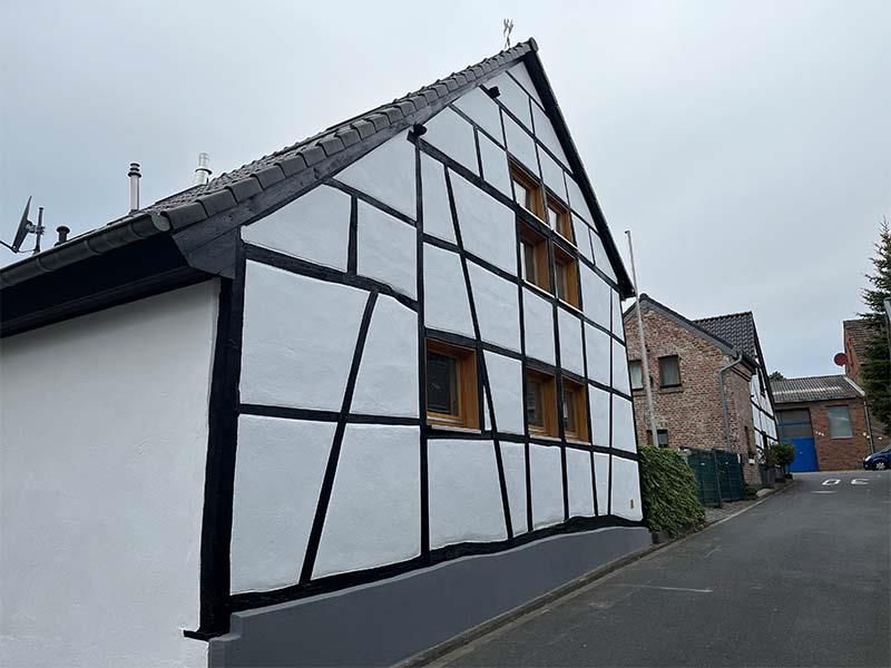 Ein weiß-schwarzes Gebäude mit einem schwarzen Dach