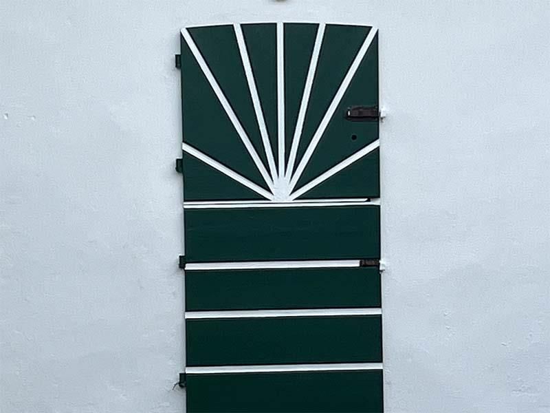 Eine grüne Tür mit weißen Streifen darauf