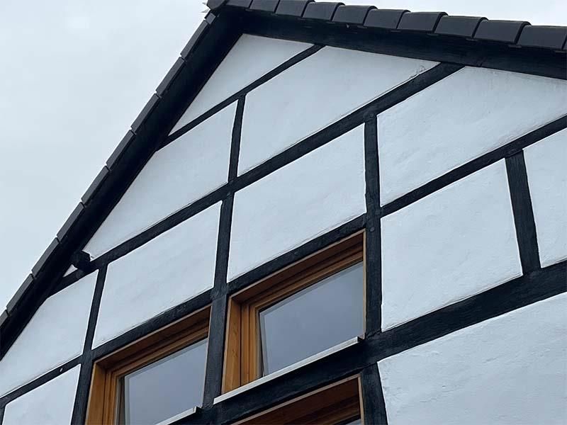 Ein schwarz-weißes Gebäude mit einem Fenster an der Seite