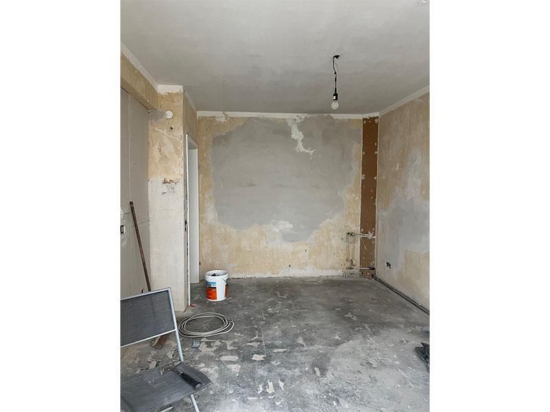 Ein Raum mit einem Stuhl und einem Eimer auf dem Boden.