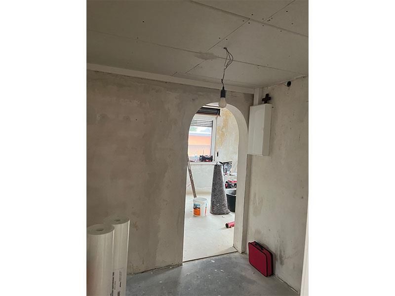 Ein Raum mit einer Tür, die zu einer Küche führt.