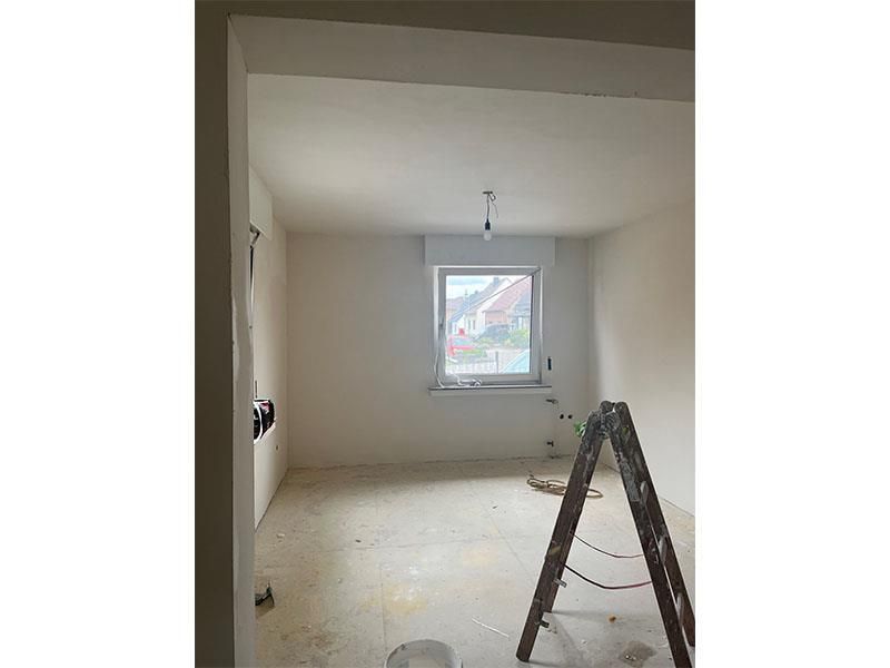 Ein Raum mit einer Leiter und einem Fenster.