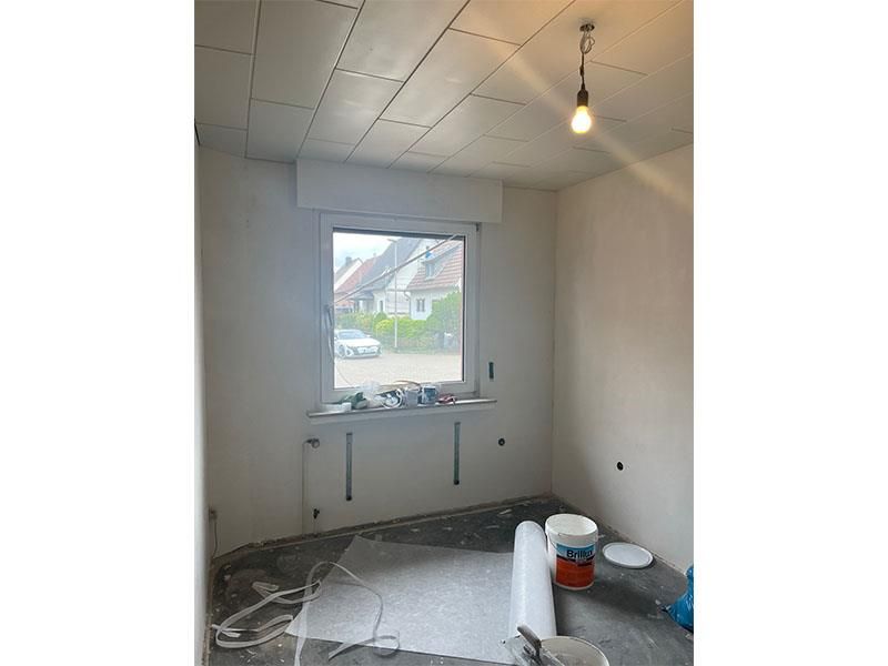 Ein Raum mit einem Fenster und einer Deckenleuchte.