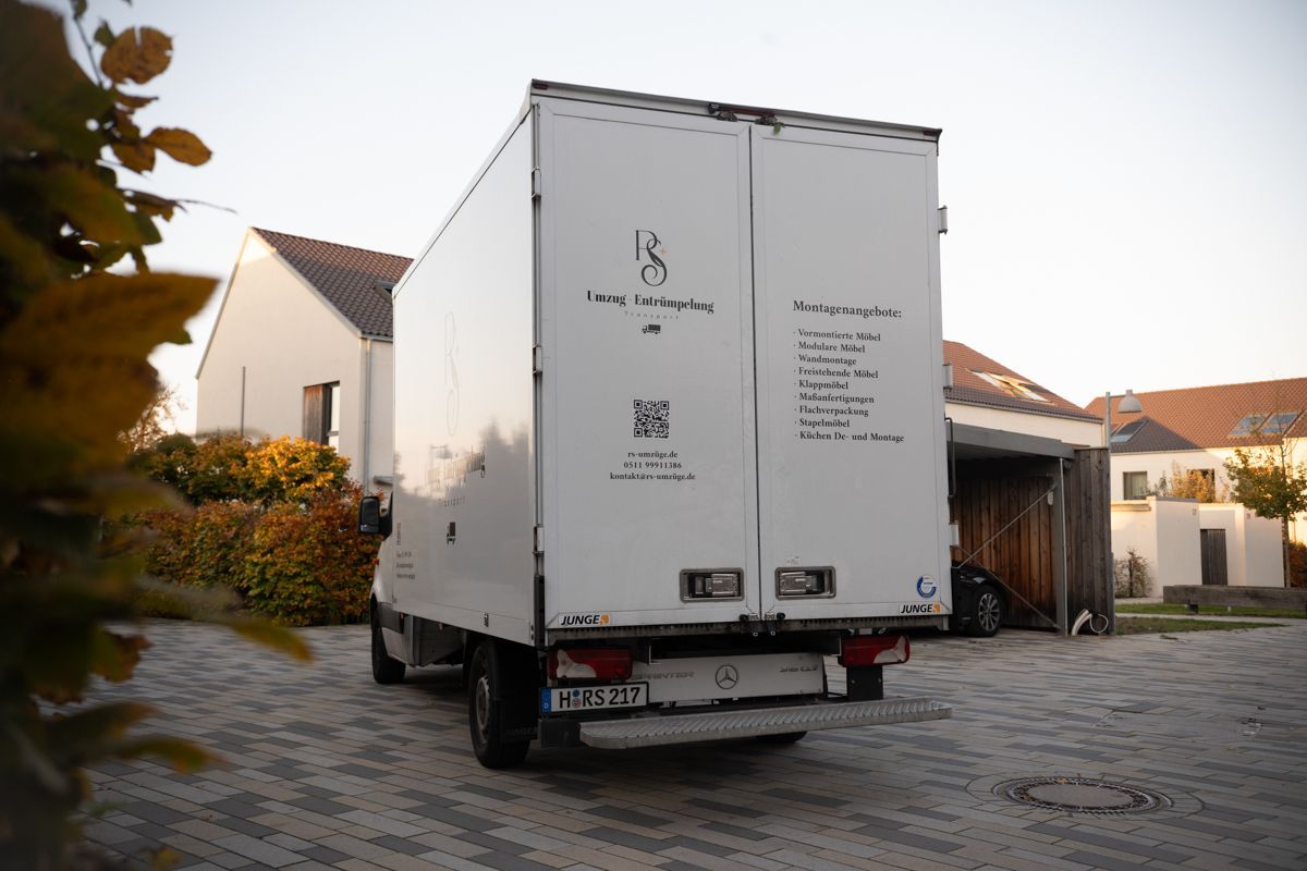 Ein weißer Lastwagen steht in der Einfahrt vor einem Haus.