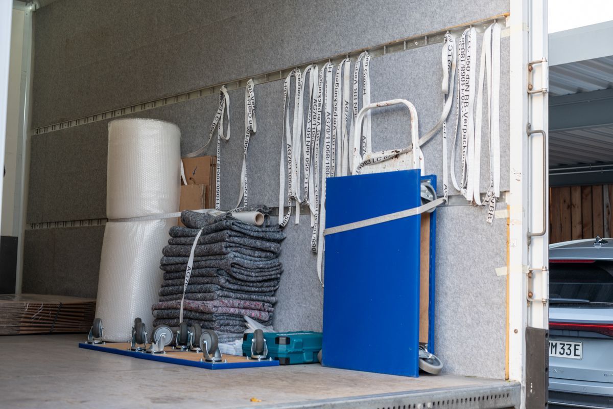 Die Ladefläche eines Umzugswagens ist mit viel Umzugsmaterial beladen.