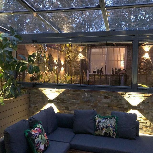 Un sofá está sentado bajo un techo de cristal en una habitación.