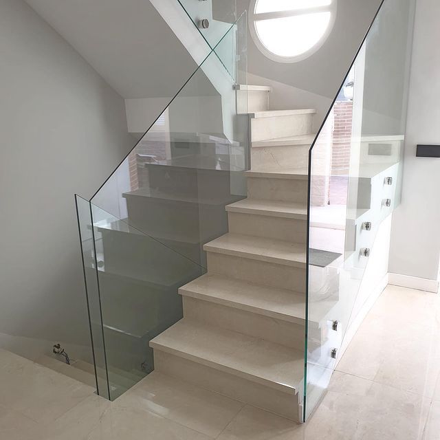Una escalera con barandilla de cristal en una casa