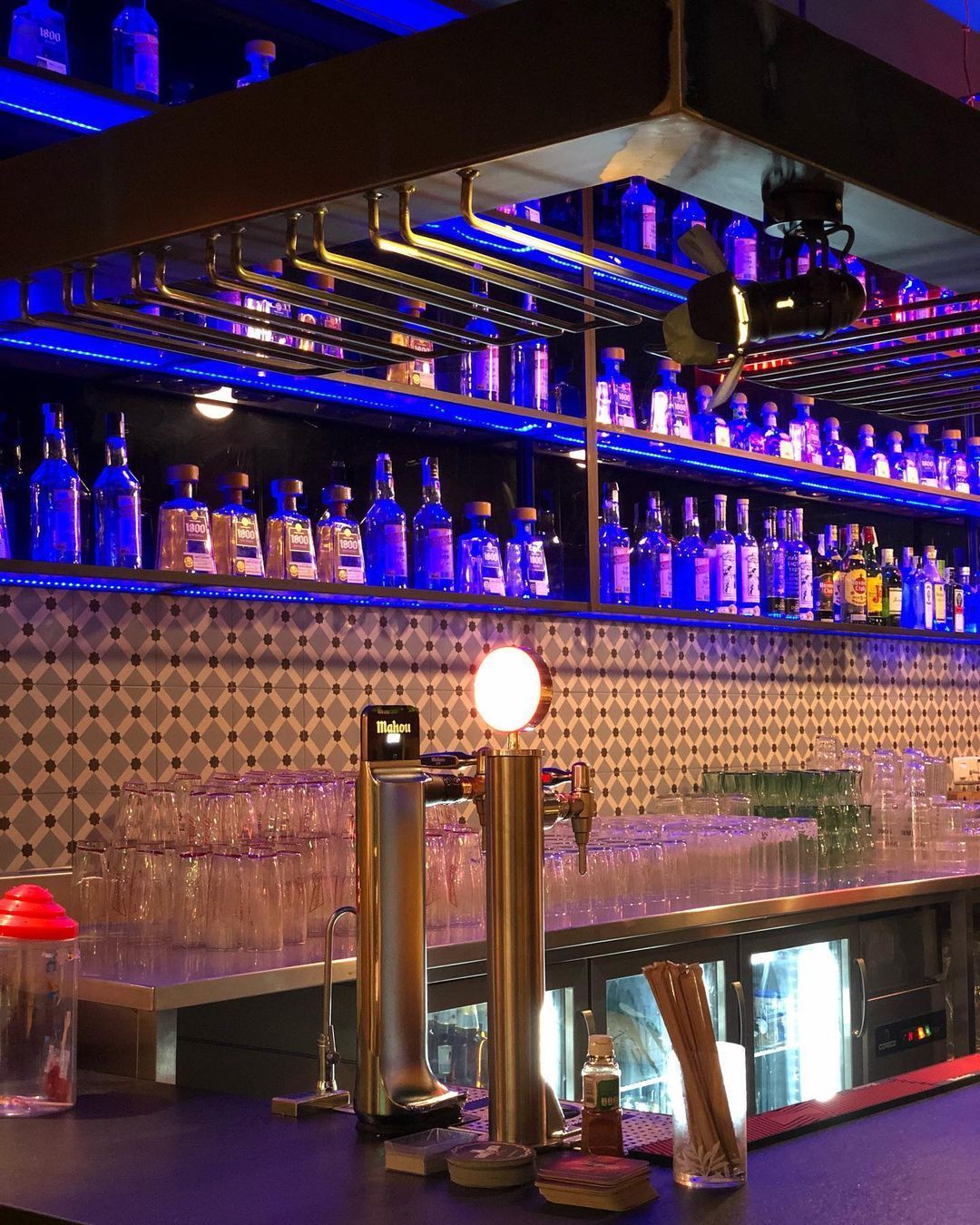 Un bar con muchas botellas en los estantes.