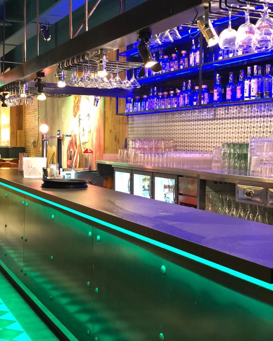 Un bar con muchas botellas y vasos encima.