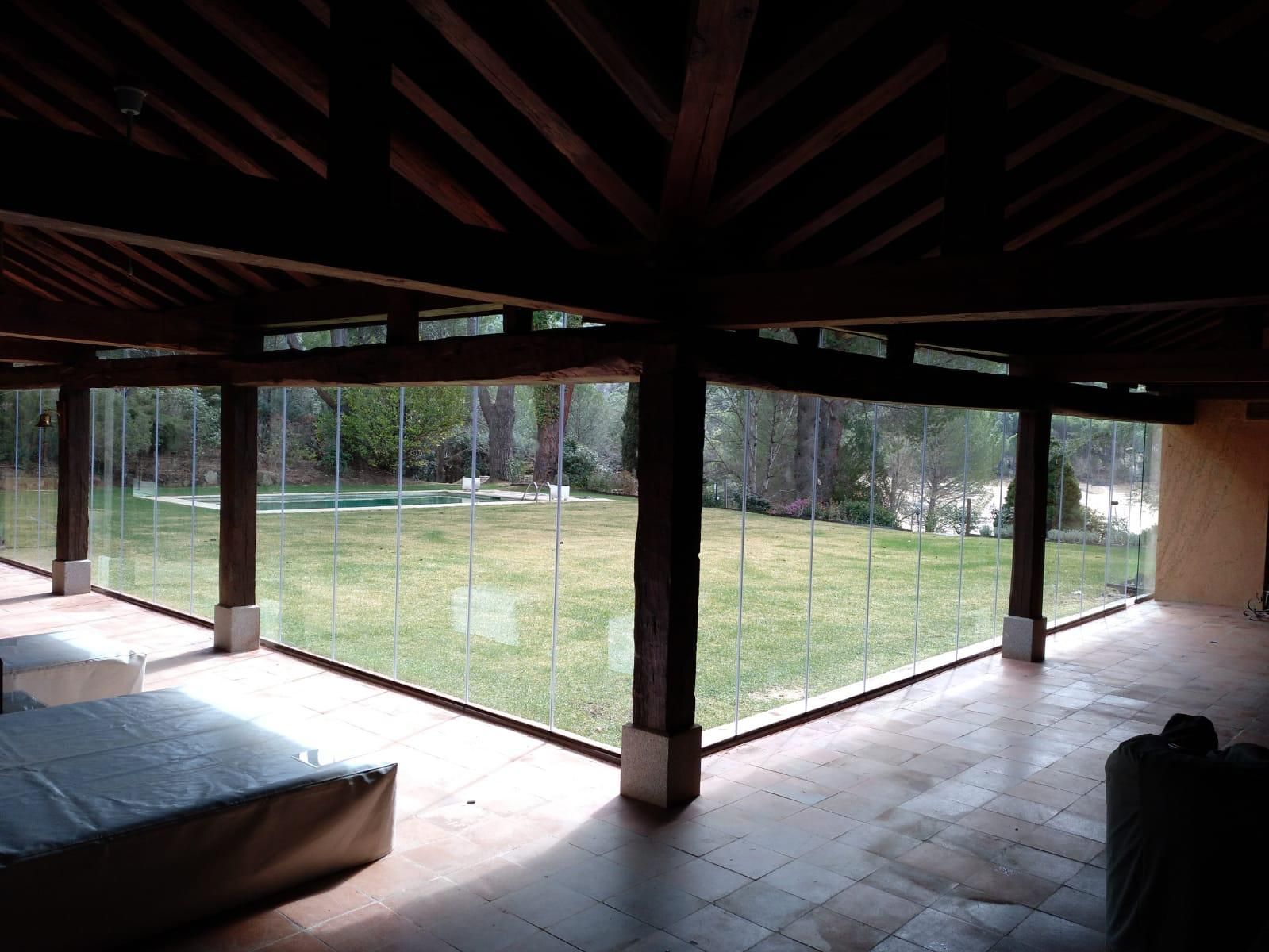 Una habitación grande con muchas ventanas y una piscina al fondo.