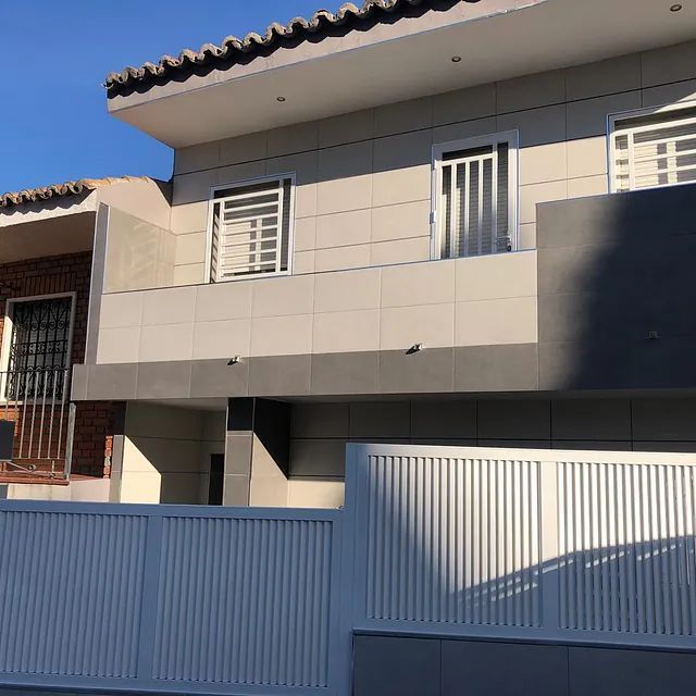 Una casa con una valla blanca delante