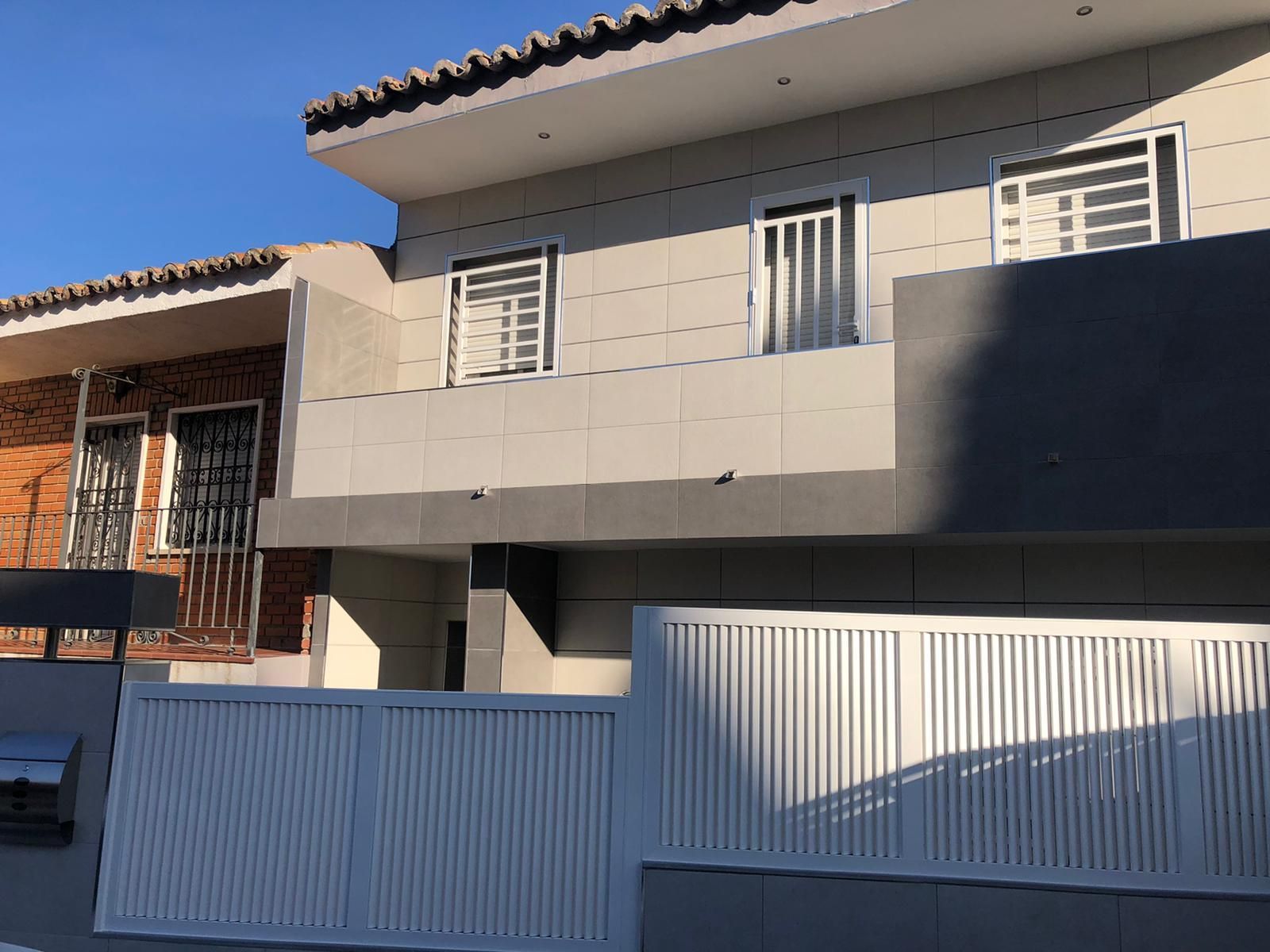 Una casa con una valla blanca delante