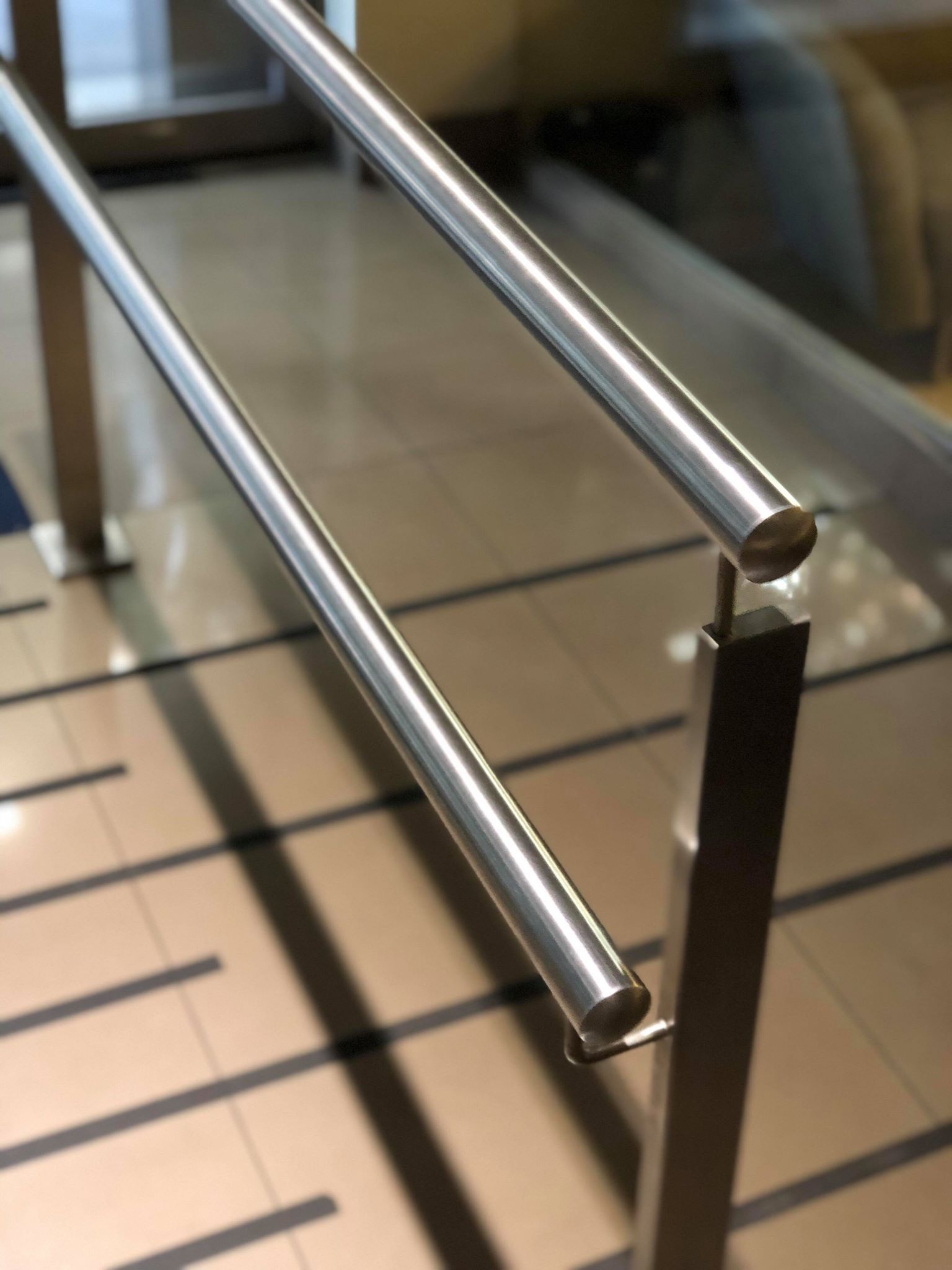 Un primer plano de una barandilla de acero inoxidable en una escalera.