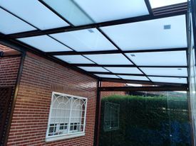 Una casa de ladrillo con una ventana y un dosel encima.