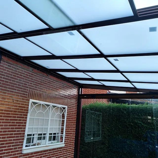 Un edificio de ladrillo con techo de cristal y una ventana.