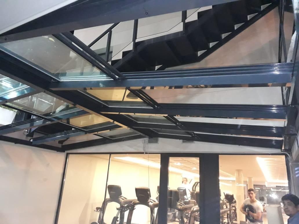 Un gimnasio con escaleras que conducen al segundo piso.