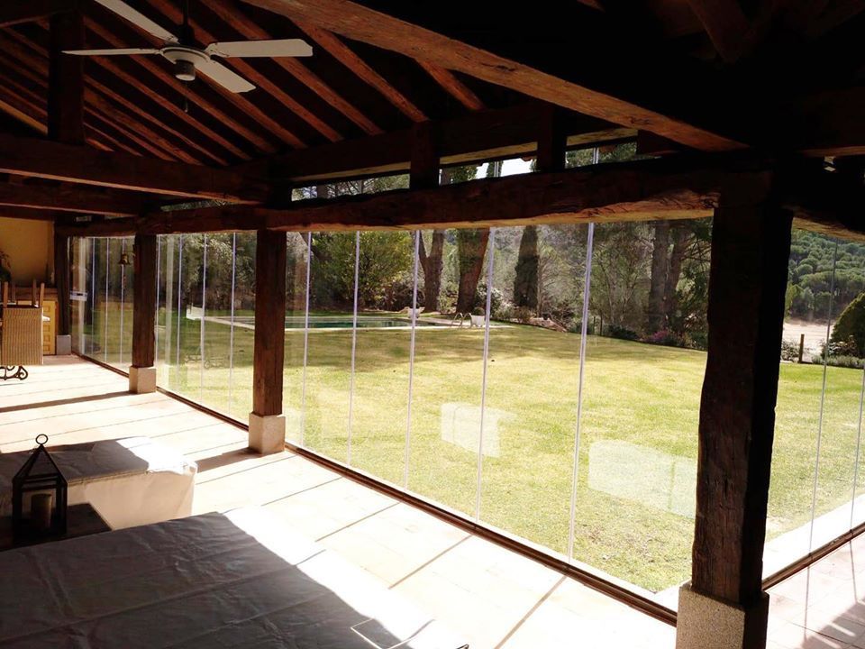 Una habitación con muchas ventanas y un ventilador de techo.