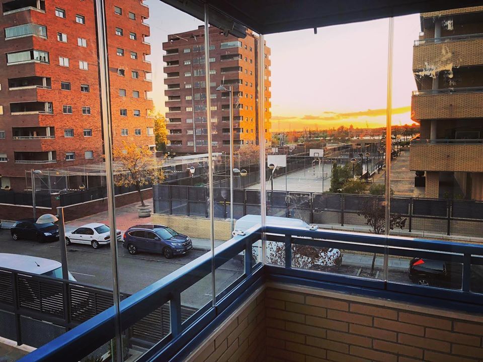 Un balcón con vista a una calle de la ciudad y edificios.