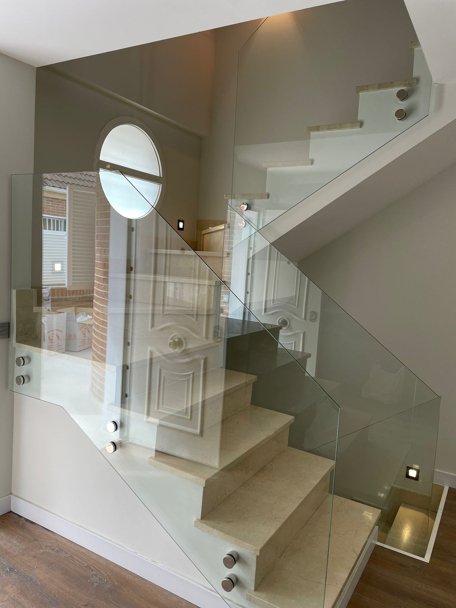 Una escalera con barandilla de cristal en una casa.