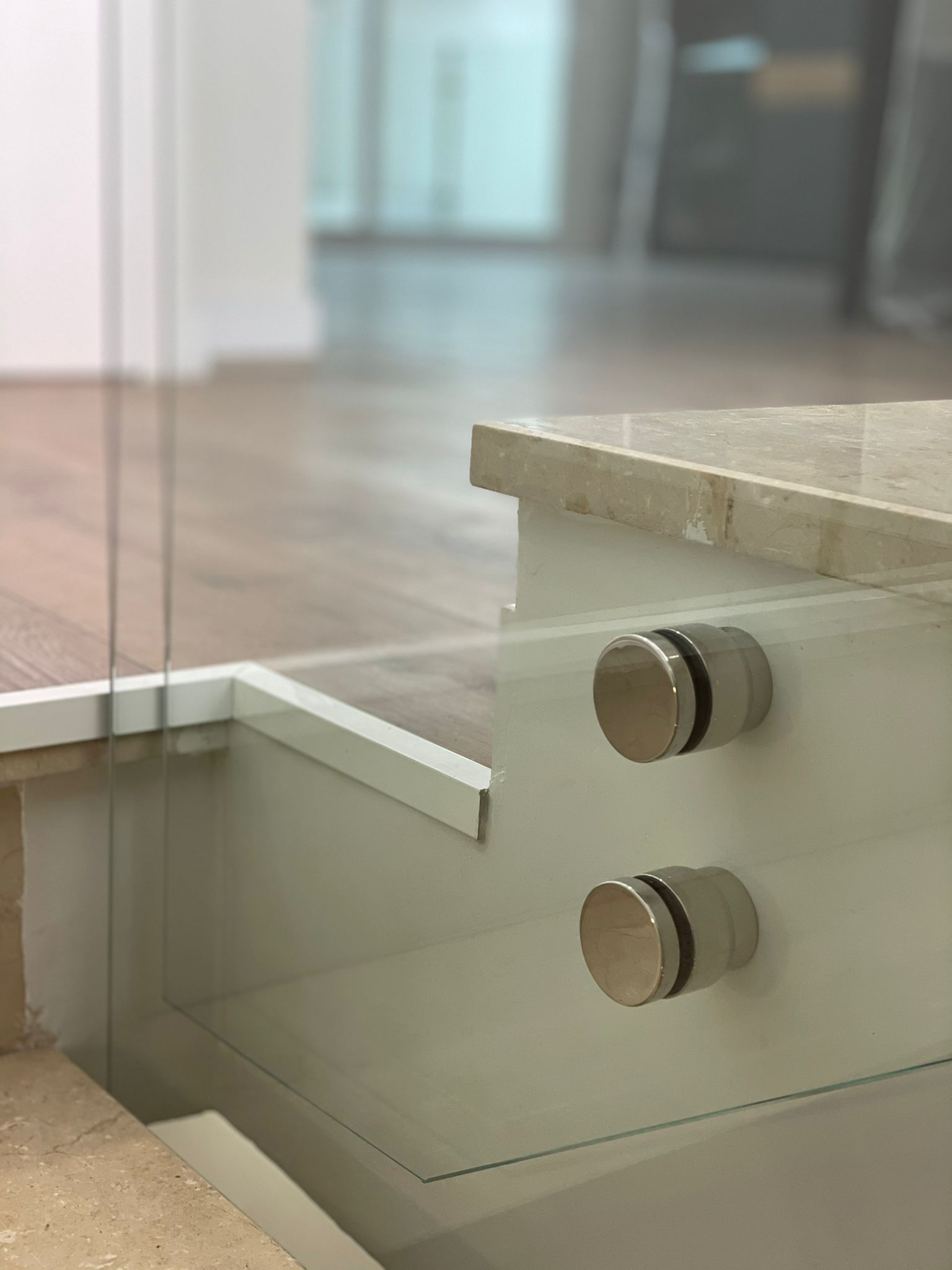 Un primer plano de una barandilla de vidrio en una escalera.