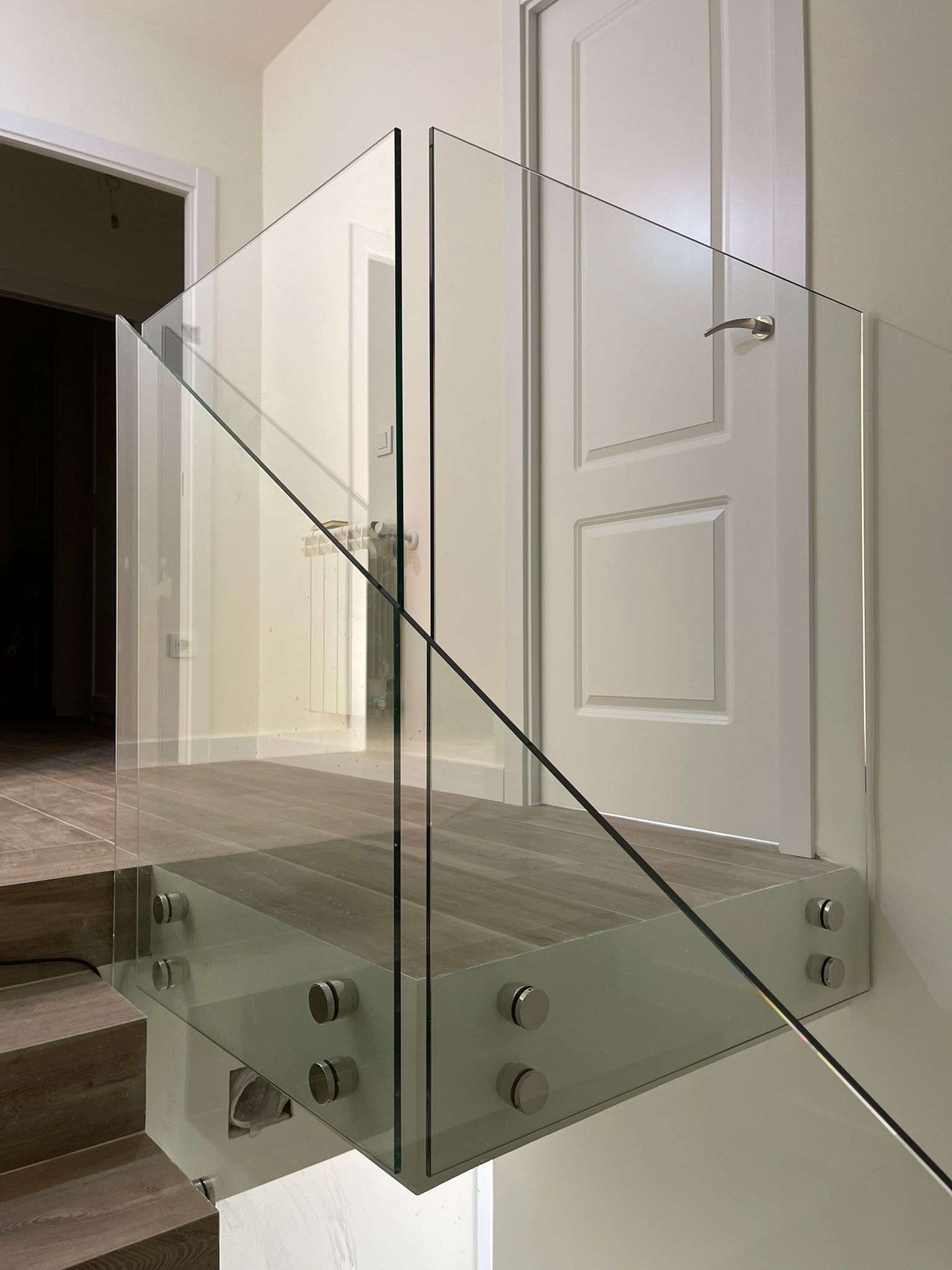 Una escalera con barandilla de cristal y barandilla de acero inoxidable.