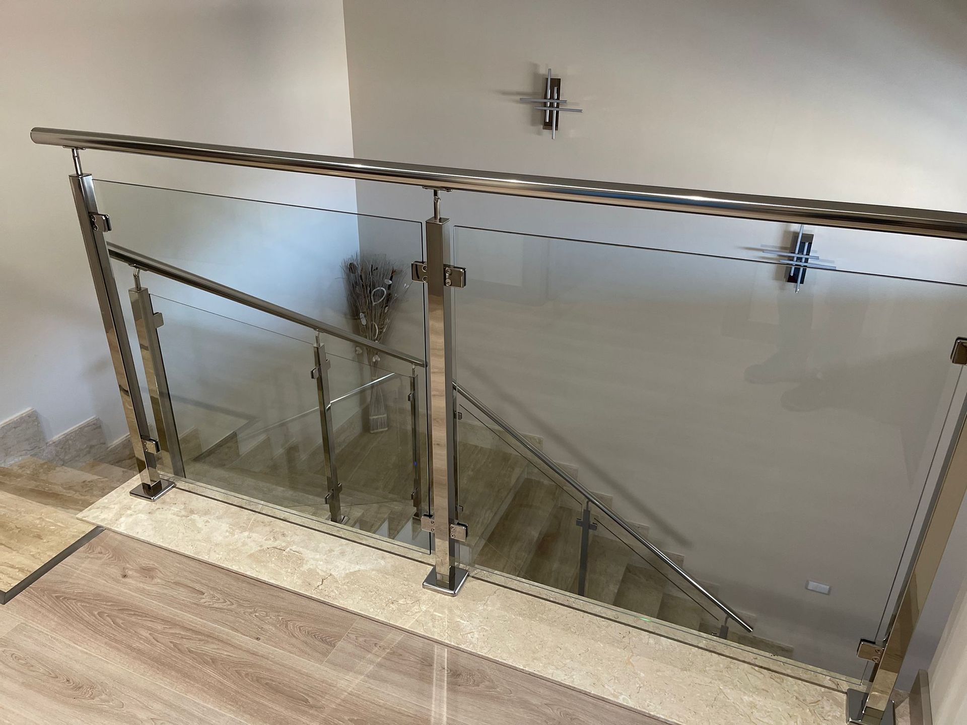 Una escalera con barandilla de cristal y barandilla de acero inoxidable.