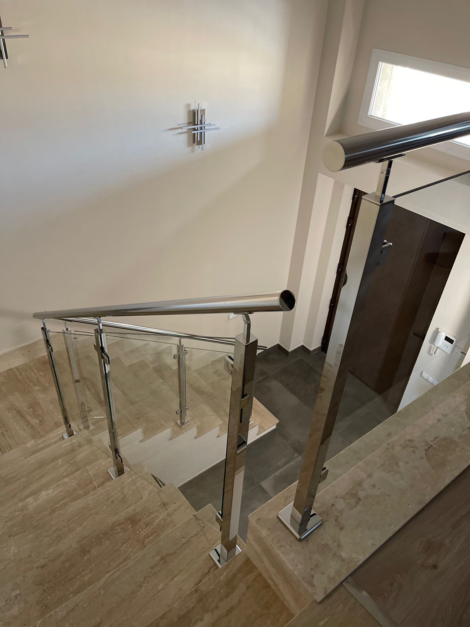 Una escalera con barandilla de acero inoxidable y barandilla de cristal.