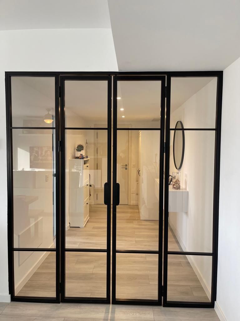 Una habitación con una puerta de cristal y un espejo en la pared.