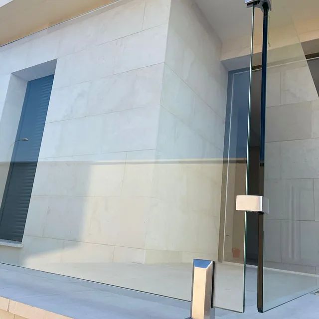 Un edificio con una barandilla de vidrio en el costado.