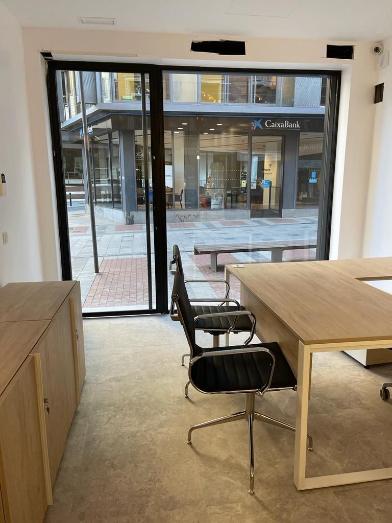 Una habitación con una mesa y sillas y una ventana grande.