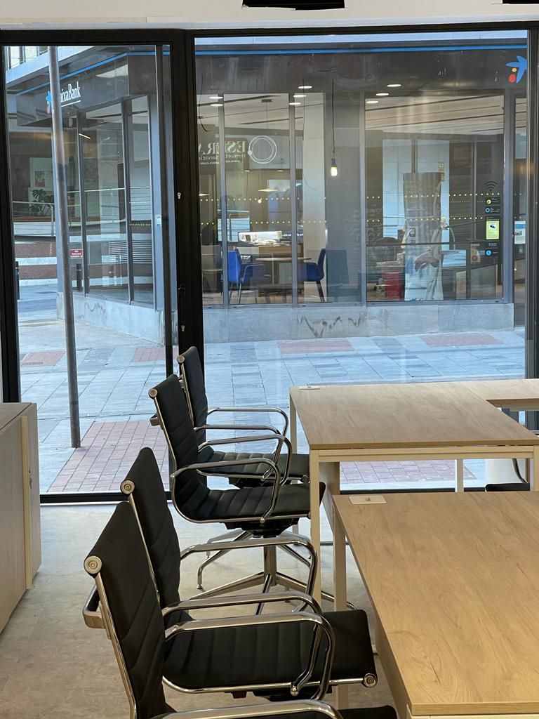 Una habitación con mesas y sillas y una gran ventana.