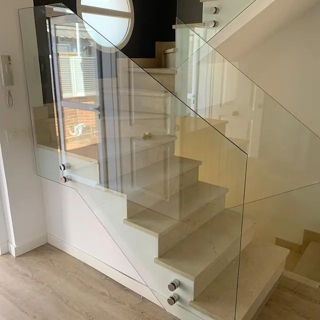 Una escalera con barandilla de cristal en una casa.