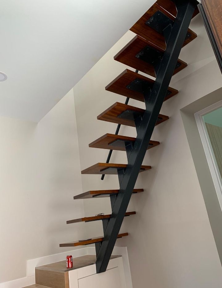 Una escalera de madera cuelga del techo de una habitación.