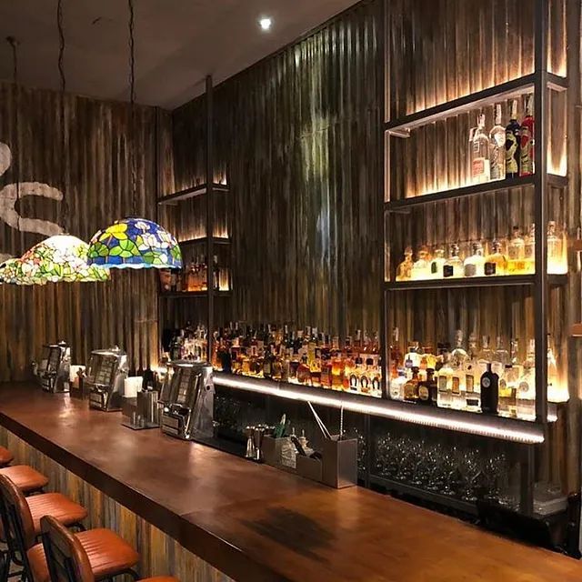 Un bar con muchas botellas de licor en los estantes.