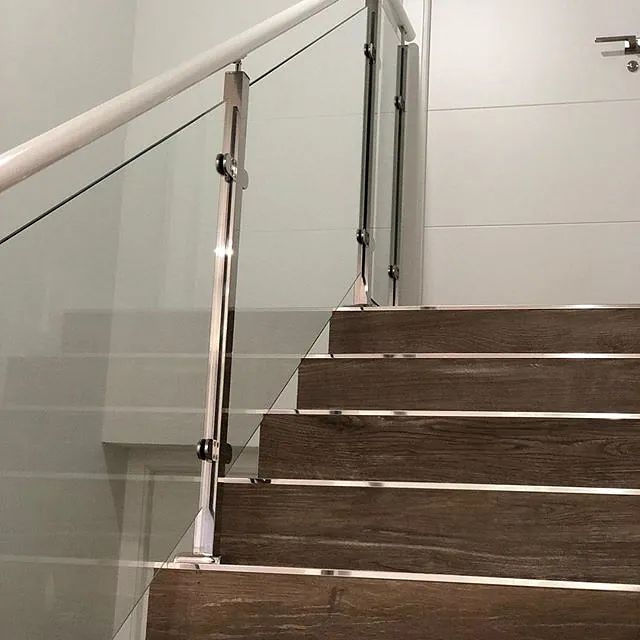 Un conjunto de escaleras de madera con barandilla de vidrio.