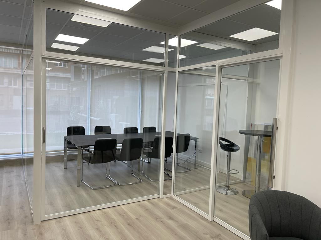 Una sala de conferencias con una mesa y sillas.