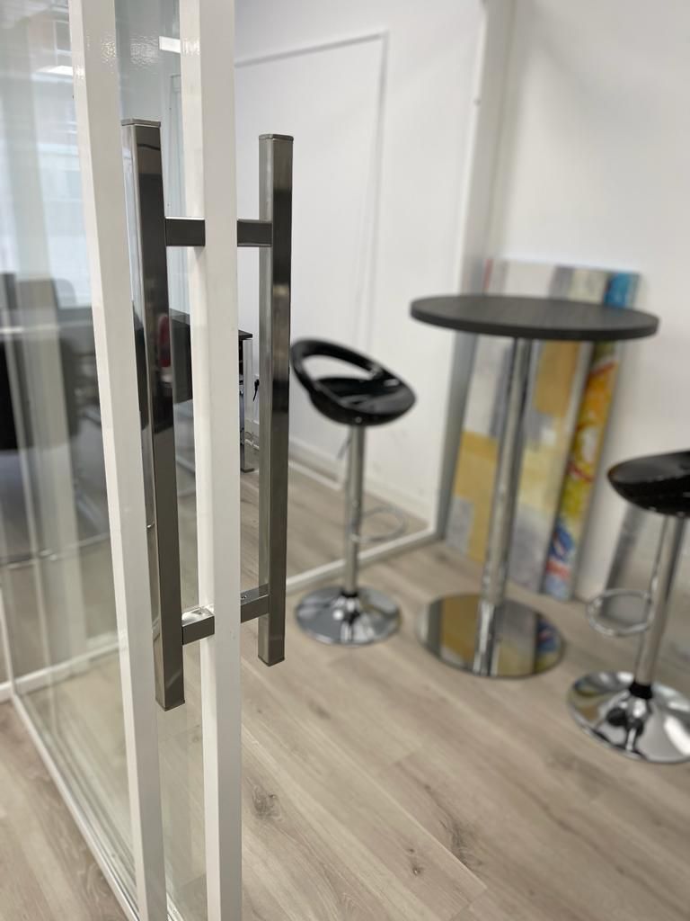 Una habitación con una mesa y taburetes.