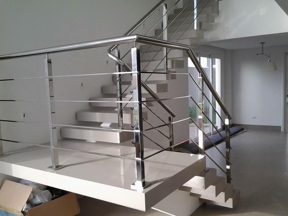 Una escalera con barandilla de acero inoxidable en una casa.