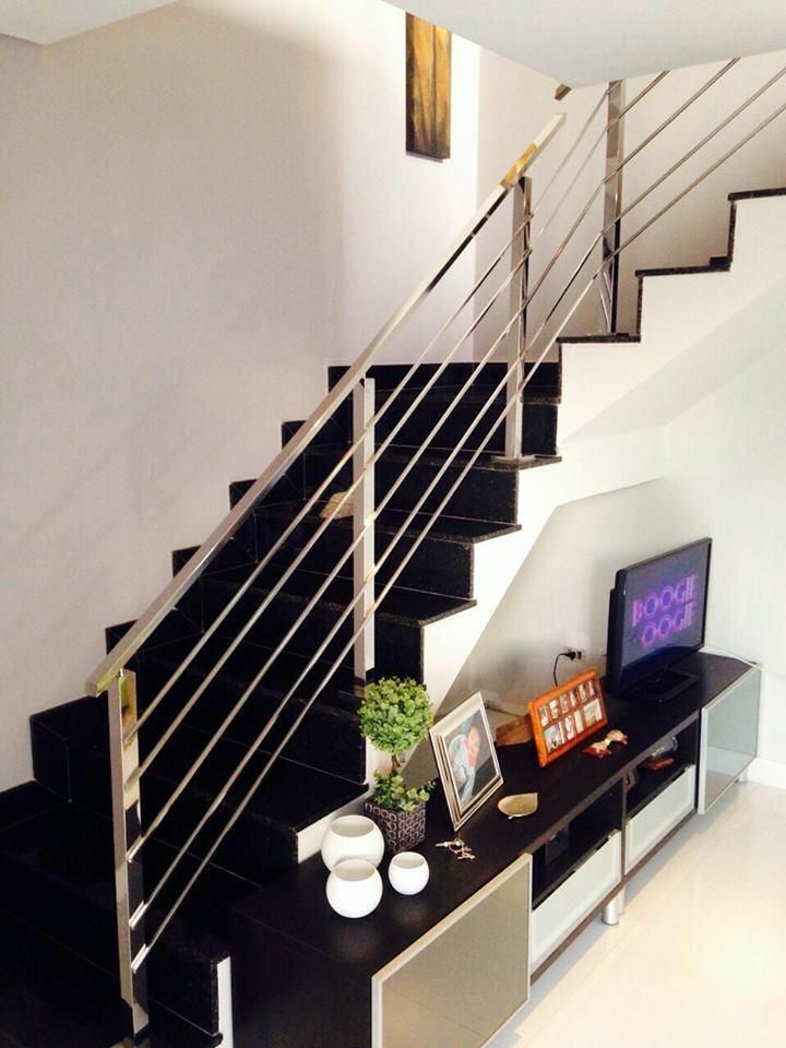 Una escalera negra con barandilla de acero inoxidable.