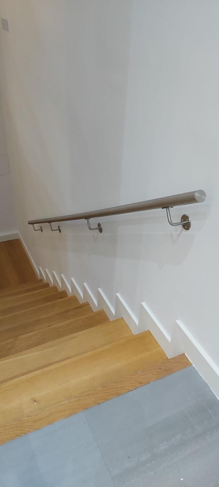 Una escalera de madera con barandilla blanca y suelo de madera.