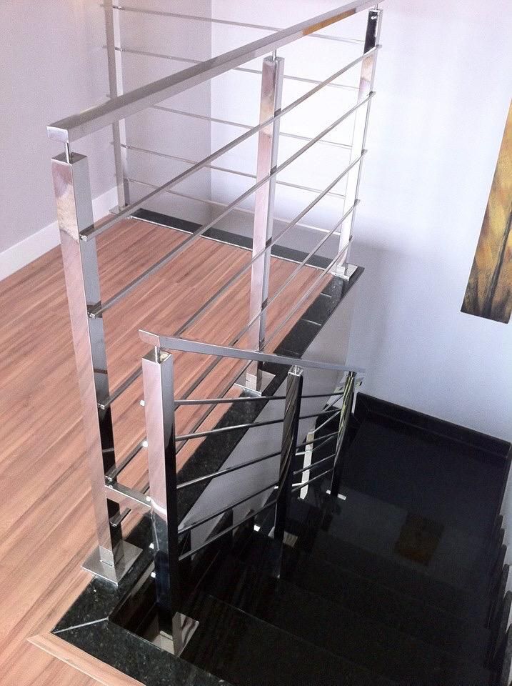 Una escalera con barandilla de acero inoxidable y escalones de madera.