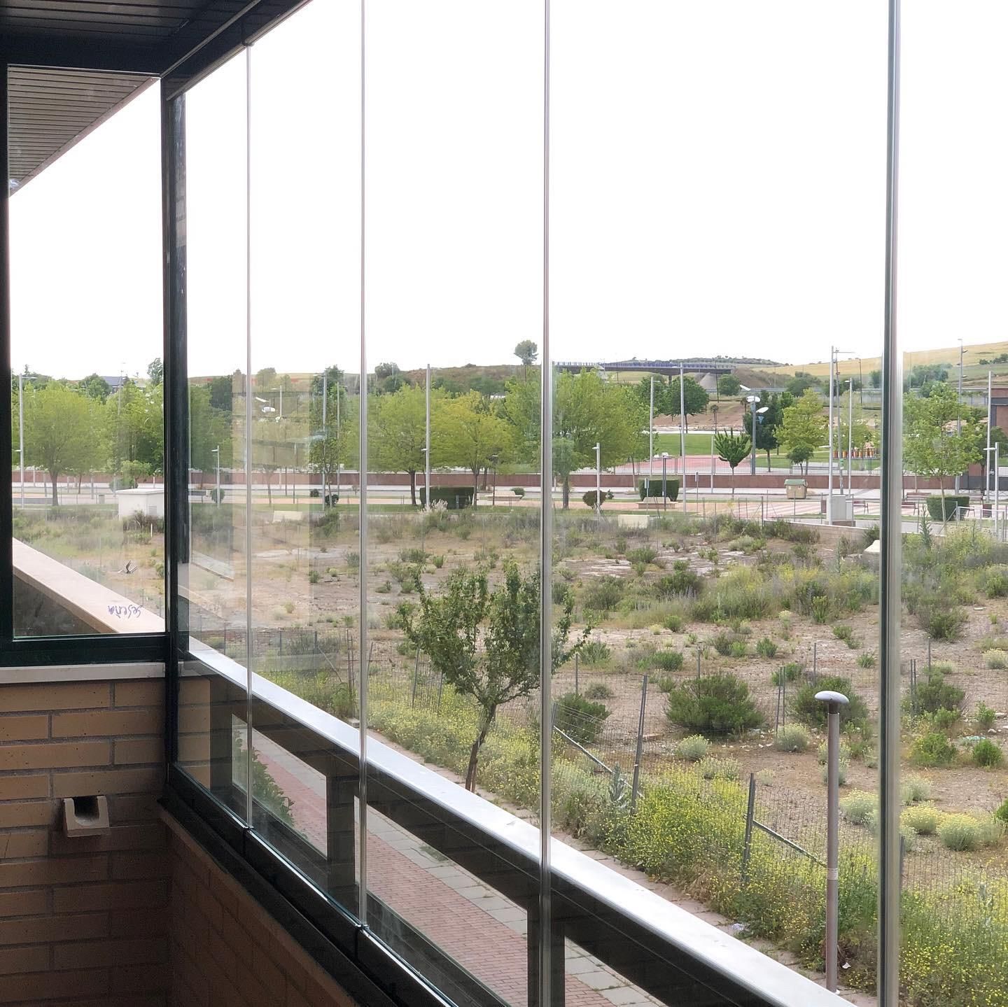 Un balcón con vista a un parque y árboles.