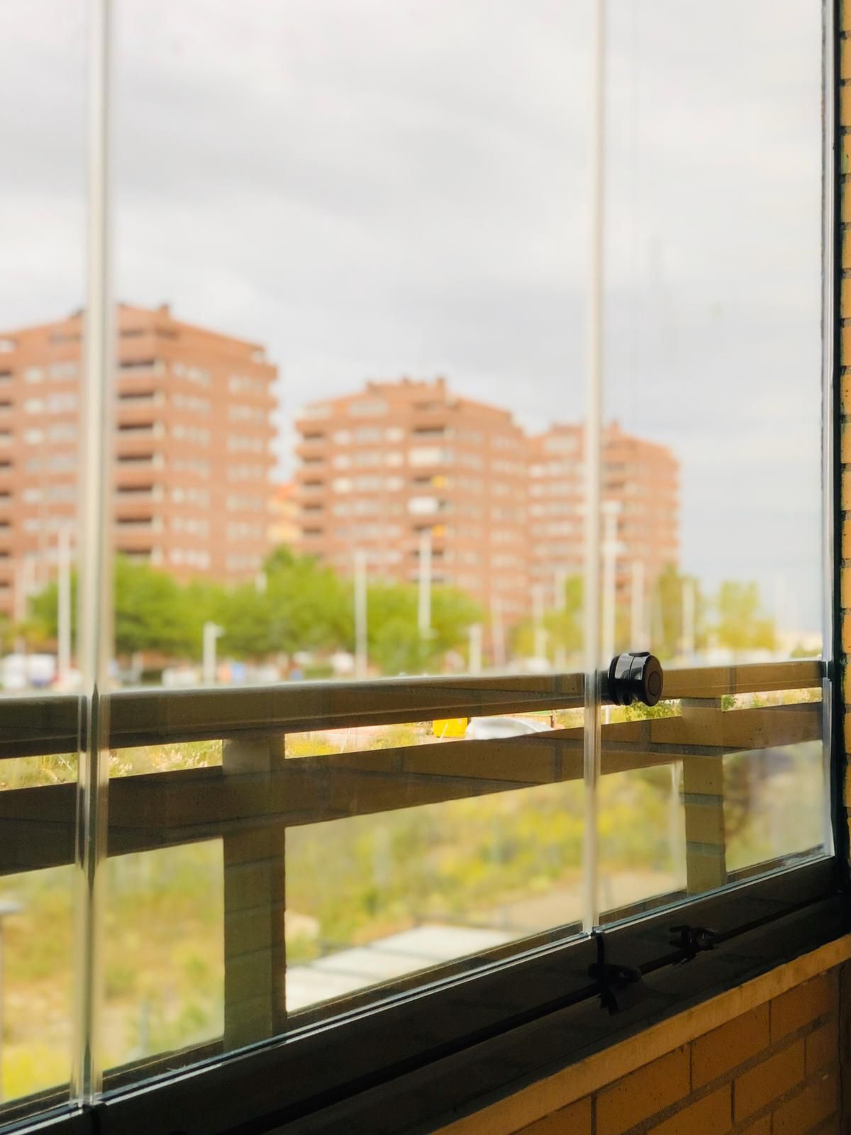 Un balcón con vista a una ciudad con edificios al fondo.