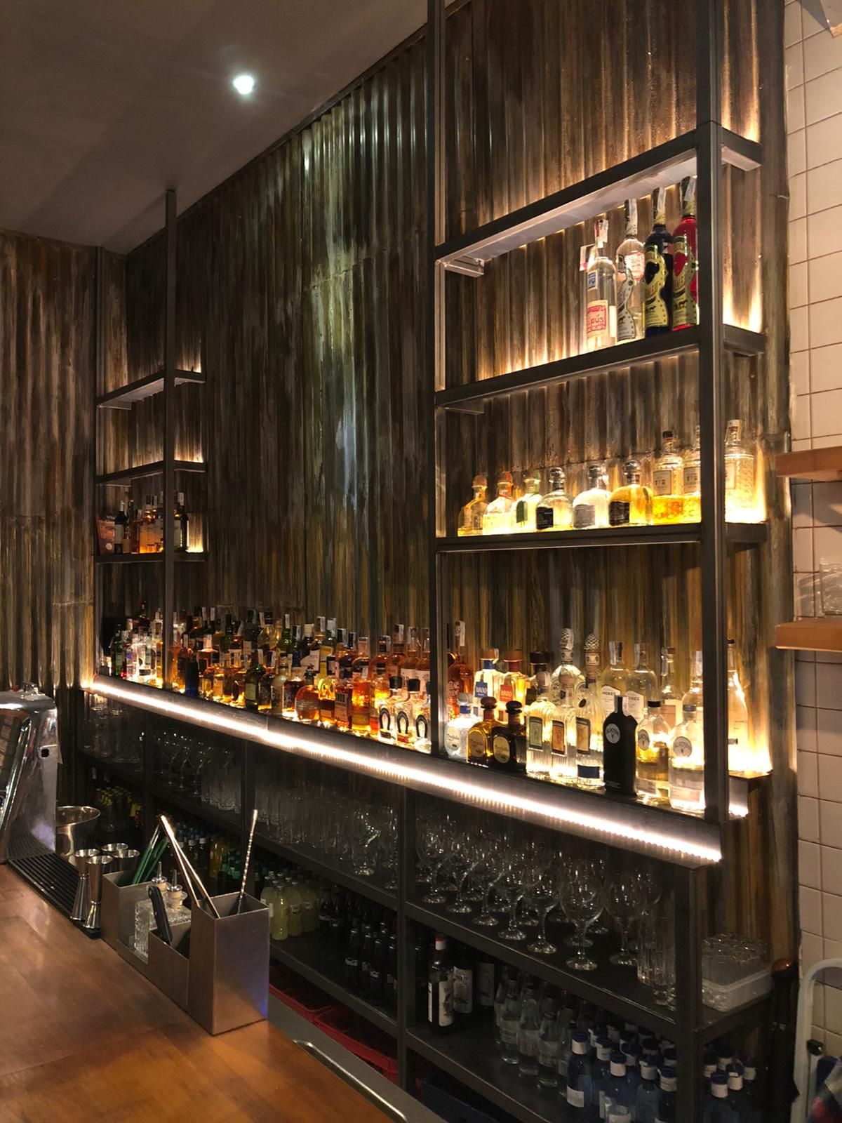 Un bar lleno de muchas botellas de licor y vasos.