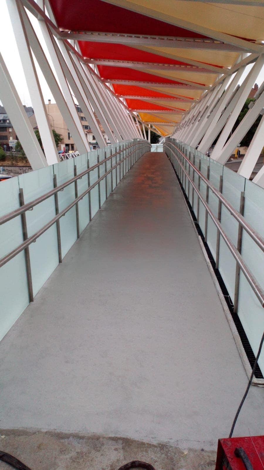 Una larga pasarela con un arco iris de colores en el techo.