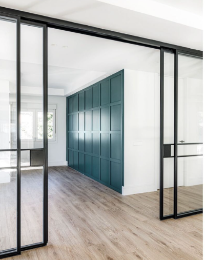 Una habitación con puertas corredizas de vidrio y piso de madera.